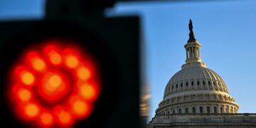 The current government shutdown, dubbed the “nuclear war of shutdowns,” has a more significant impact on federal jobs and grants compared to previous ones. President Trump is using this opportunity to freeze billions in federal grants to Democratic states and threaten layoffs among federal workers.